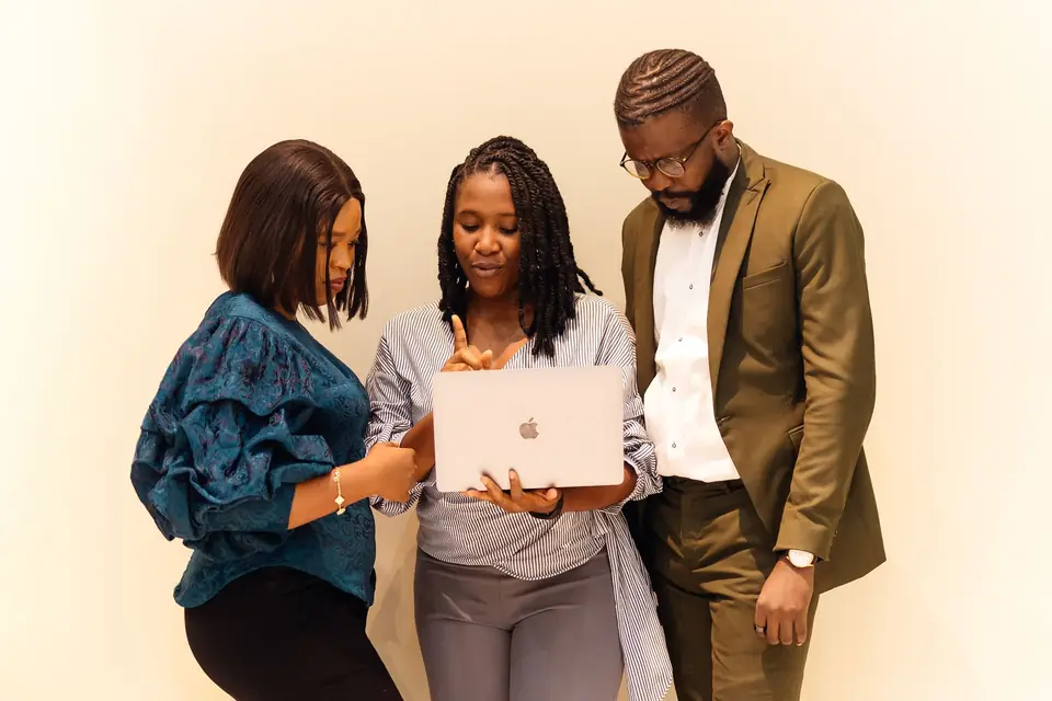 Three colleagues looking at a laptop together