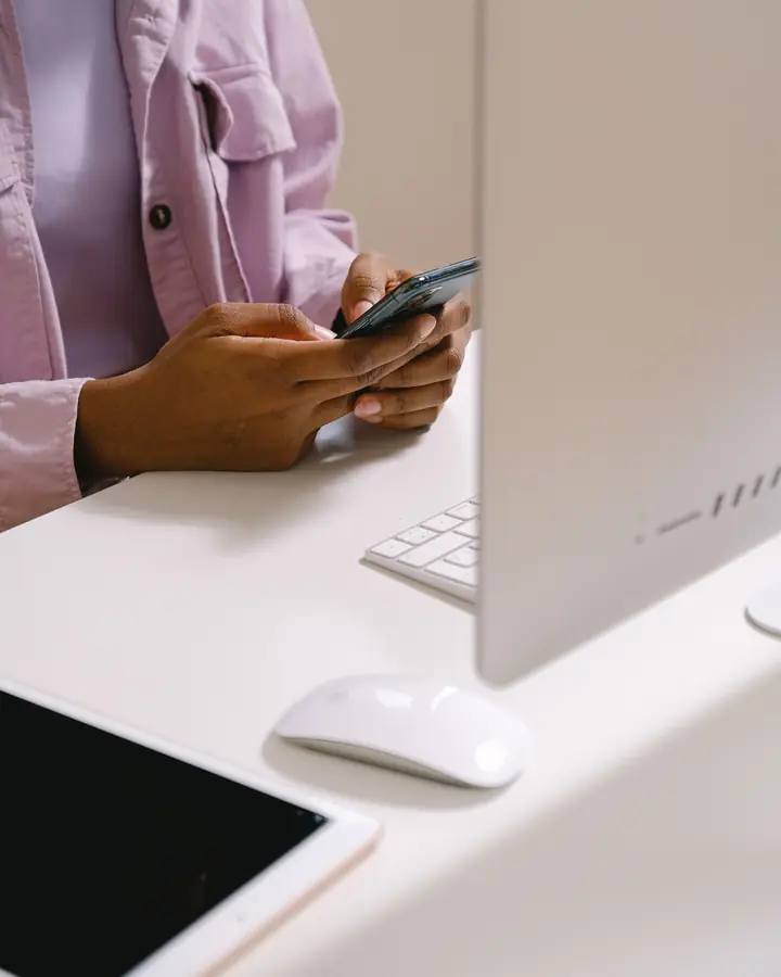A woman at her desk reading a text message on her phone